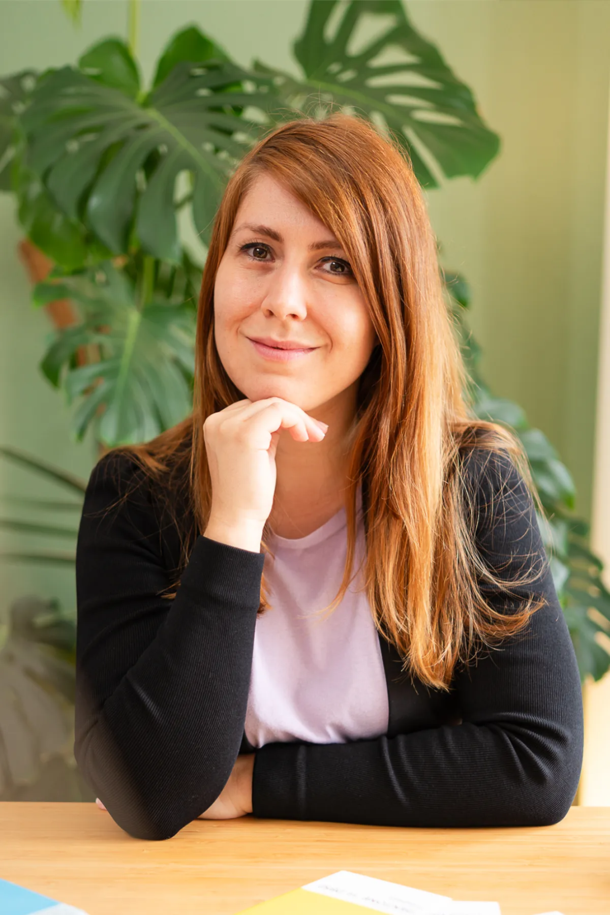 Kathrin Schönborn in ihrem Büro vor grünem Hintergrund